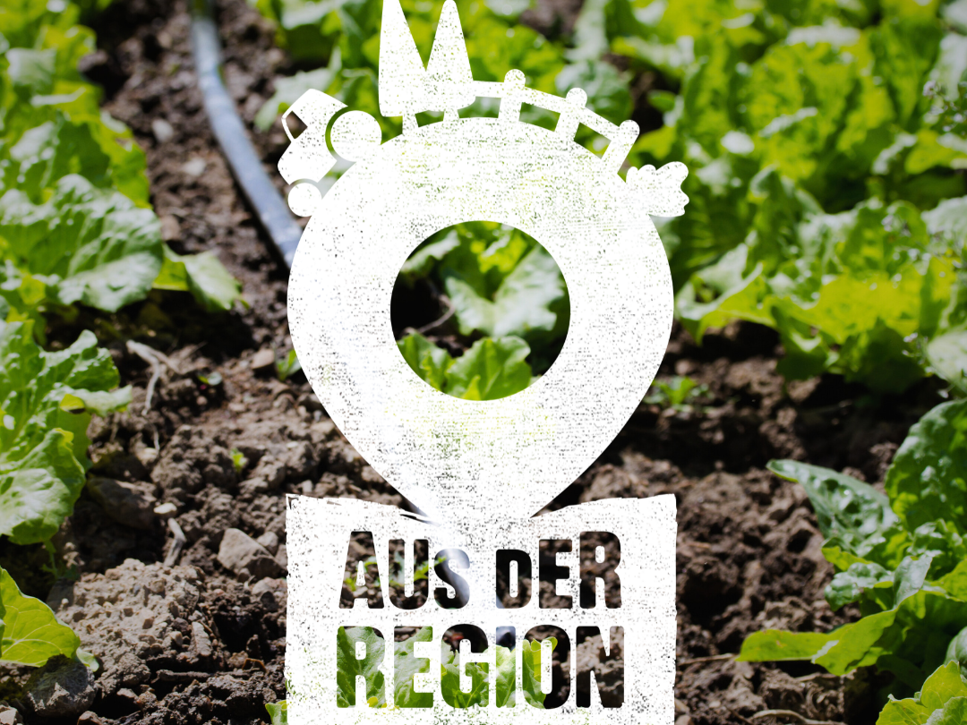 Weißes Schild auf einem Feld mit Salat: Aus der Region  - für die Region